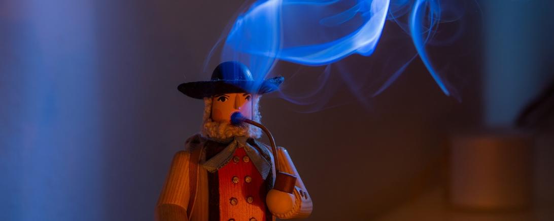 Das Bild zeigt eine räuchernde Holzfigur.