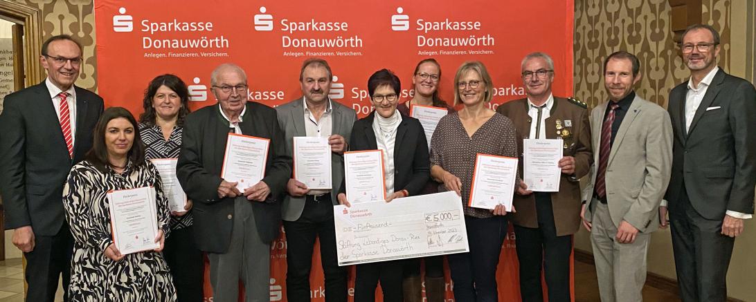 Das Bild zeigt die Übergabe der Förderurkunden in der Synagoge in Hainsfarth mit Sparkassendirektor Jo-hann Natzer, Stephanie Geyer (Kindergarten Daiting), Gertrud Wechsler (Kindergarten Fünf-stetten), Franz Eberle (Gemeinde Tapfheim), Richard Herrmann (Gemeinde Otting), Cornelia Mair (Bücherei Mertingen), Christin Lippert (Spielplatzverein Hafenreuth), Martina Tauber (Na-tur- und Erlebniskindergarten Hainsfarth), Franz Mayer (Altschützen 1885 e.V. Rögling), stell-vertretendem Stiftungsvorstand und Bürgerme