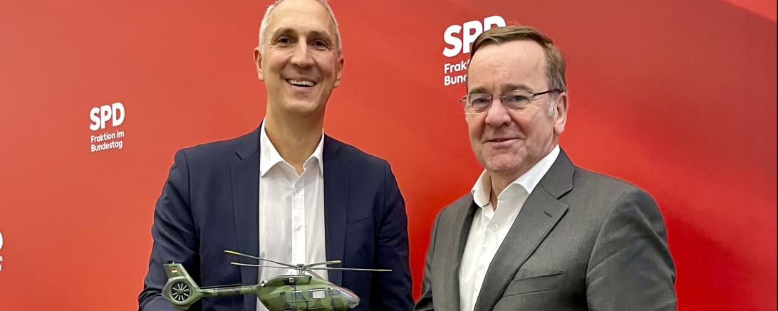 Verteidigungsminister Boris Pistorius (rechts) und Christoph Schmid halten ein Modell des neuen H145M in den Händen.
