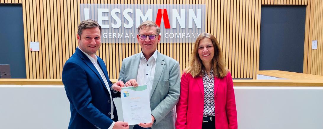 Landrat Stefan Rößle (Mitte) überreicht Daniel Lehn (links), Beauftragter für Umweltmanagement bei Lessmann, und Cornelia Kitzsteiner (rechts), Vertriebsleitung, die Urkunde für die Aufnahme in den Umweltpakt.