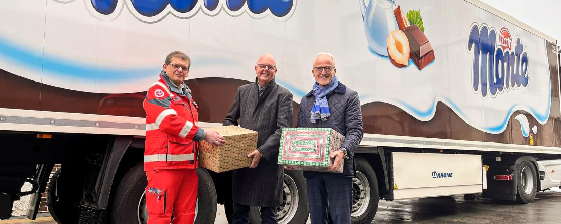 Frank Uszko (Mitte), Chief Executive Officer und Anton Hammer (rechts), Chief Financial Officer von Zott übergaben am 12. Dezember 2023 stellvertretend die von Zott und den Mitarbeitenden gepackten Weihnachtspakete an die Johanniter.