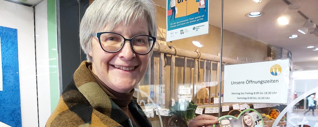 Geschäftsführerin Christiane Kickum mit dem Aufkleber „Dorfladen mit Herz“.