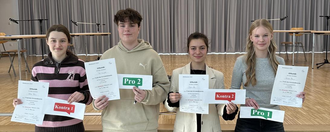 Die Finalteilnehmer (von links nach rechts) Ester Hahn, Paul Baumgärtel, Sophia Akin und Franka Holzmann mit den von ihnen vertretenen Positionen.