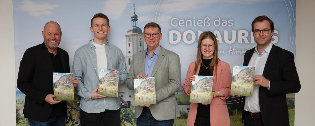Geschäftsführer Magenta4 Klaus Dorsch und Projektleiter Jonas Dorsch, Landrat Stefan Rößle, Projektleiterin Lorena Eberhart und Geschäftsführer des Ferienlandes DONAURIES e.V. Klemens Heininger präsentieren das DONAURIES Magazin 2024.