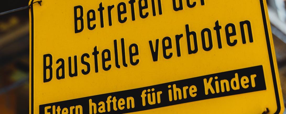 Baustellenschild mit der Aufschrift "Betreten der Baustelle verboten, Eltern haften für ihre Kinder"