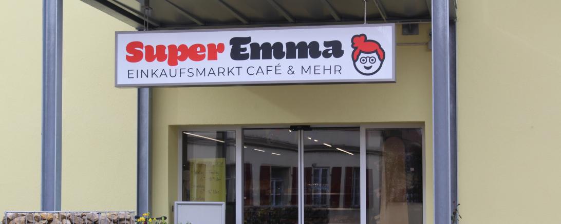 Zu sehen ist das Ladenschild über der Tür mit dem Namen Super Emma.