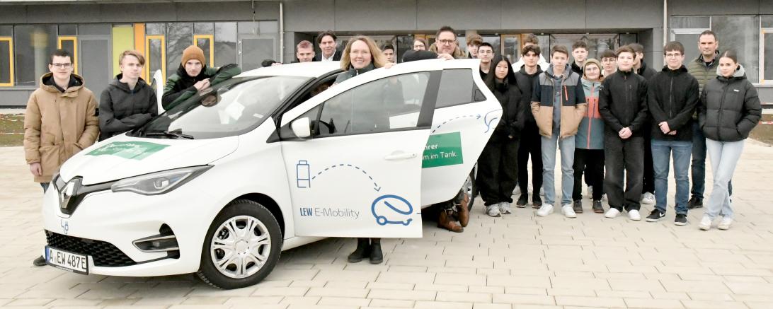 Die Klasse 10a der Realschule Rain hinter einem E-Auto