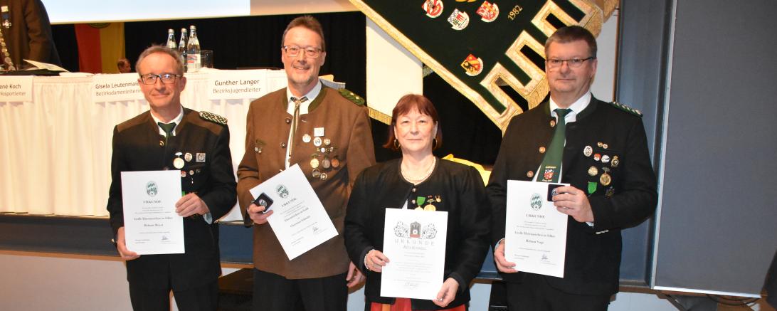 Vier Menschen, die Jeweils eine Urkunde halten.