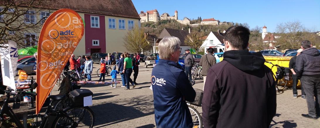 Zwei Menschen im Vordergrund, Menschen laufen im Hintergrund und das Schloss Harburg ist zu sehen