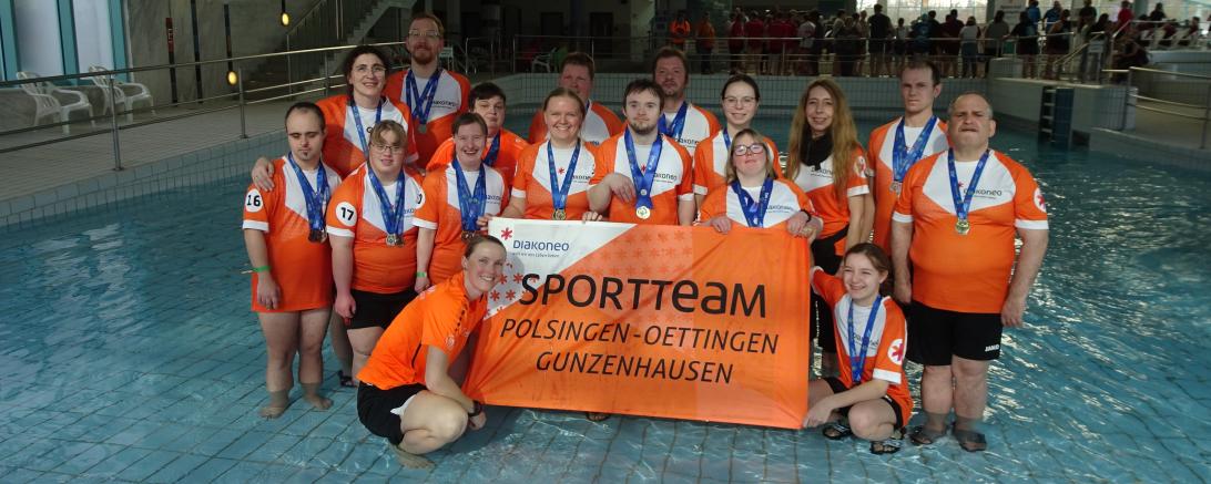 Das Schwimmteam in oranger Kleidung