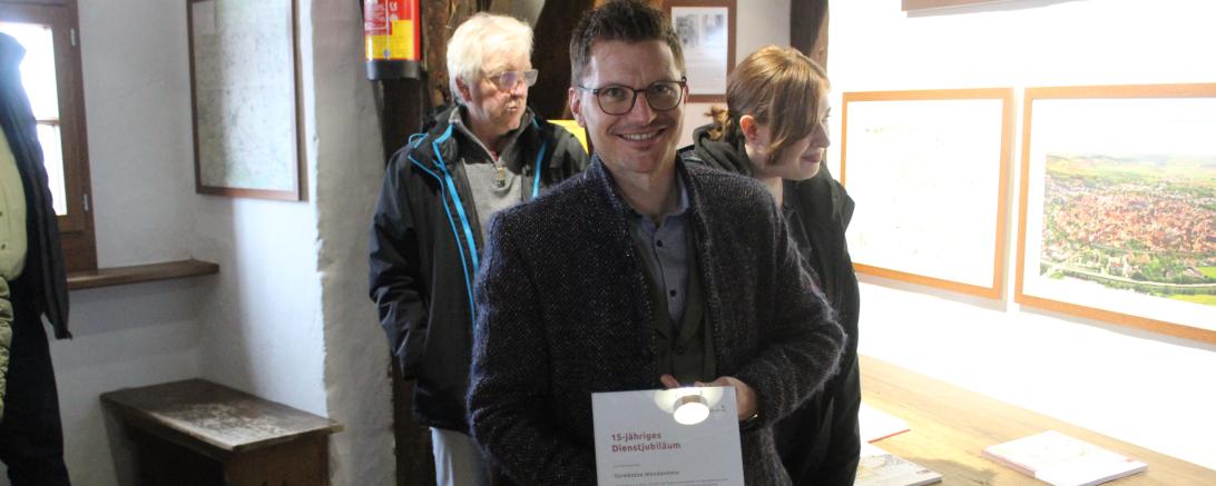Hier sieht man Nördlingens Oberbürgermeister mit Urkunde und Präsentkorb für Turmkatze Wendelstein.