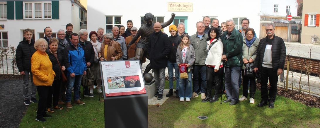 Hier sieht man Dr. Michael Bast (rechts neben der Statue) und die Teilnehmer der ersten Gerd-Müller-Führung in Nördlingen.
