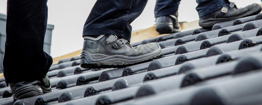 Oben auf dem Dach wartet jede Menge Arbeit – und für die gibt es ein „Mindest-Lohn- Preisschild“: 15,60 Euro pro Stunde – das ist das Minimum, was Gesellen auf dem Dach verdienen müssen.