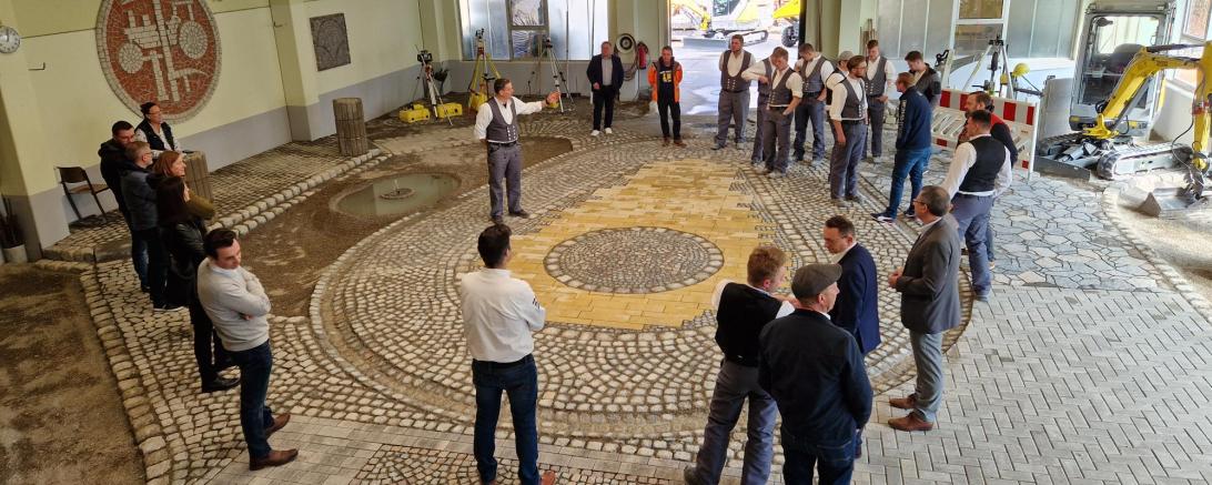 Die Teilnehmer an der Projektwoche „Begabtenförderung Straßenbauer“ blicken stolz zusammen mit den Ausbildern und Vertretern der Politik auf ihre Arbeit in der der Straßenbauhalle der Bauinnung Nordschwaben in Nördlingen