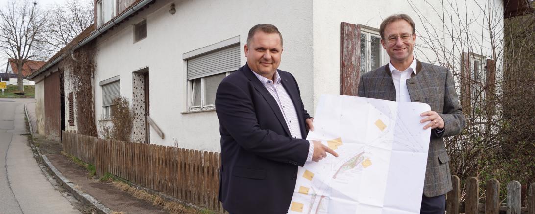 : Das Foto zeigt Bürgermeister Marcus Späth (links) und MdL Wolfgang Fackler vor dem Haus in der Prinz-Eugen-Straße in Brachstadt, das abgerissen wird. Darauf sieht man links hinten entlang des Stadels auch das Problem des nicht vorhandenen Gehwegs, das im Sinne der Verkehrssicherheit nun gelöst wird wird. 
