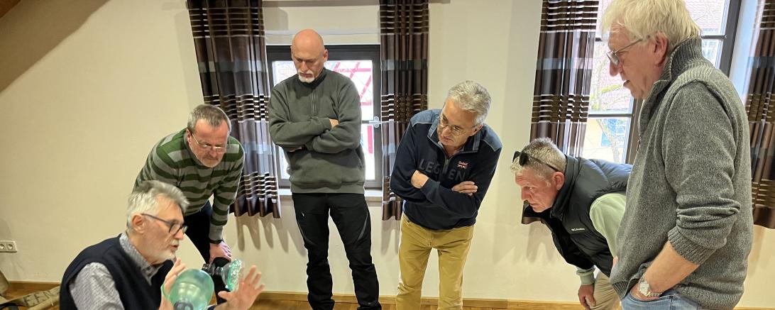 Menschen die um einen Dummy herumstehen und Erste Hilfe üben