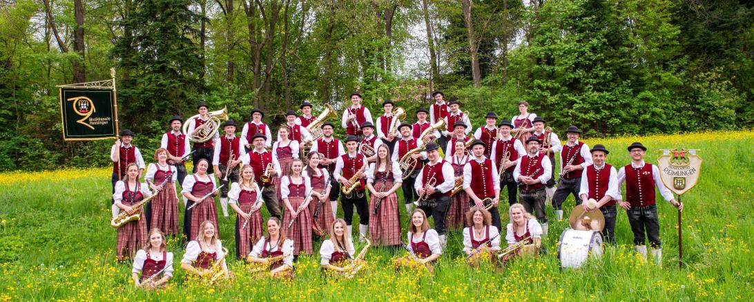 Menschen in Roten Trachten auf einer Wiese 