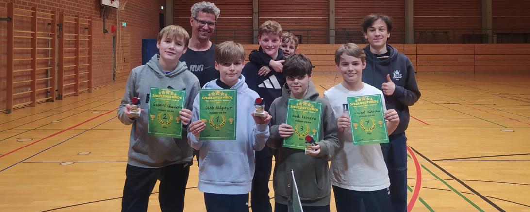 Die Sieger des Tischtennisturniers halten ihre grünen Urkunden und Pokale stolz in der Hand