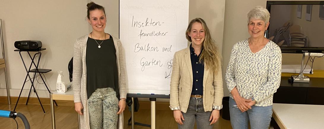 Drei Personen, die vor einem Flipchart stehen, auf dem „Insektenfreundlicher Balkon und Garten" steht.