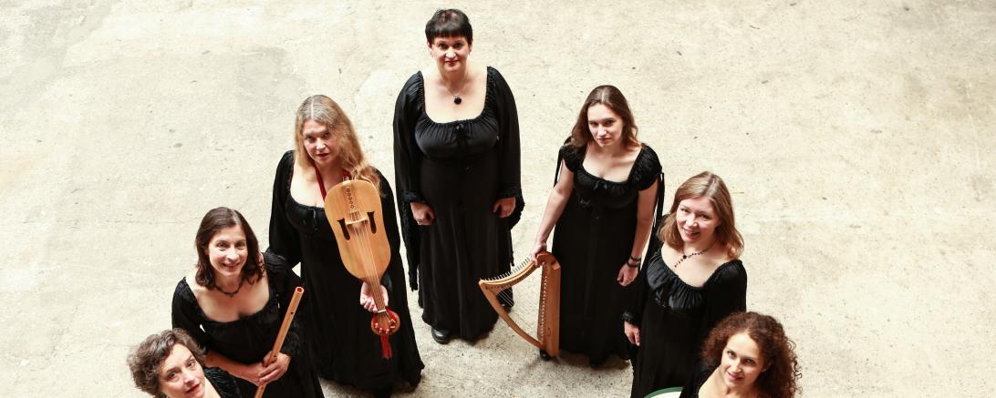 Menschen die im Halbkreis stehen und ein Schwarzes Kleid anhaben