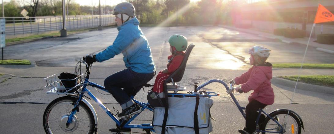 Das Bild zeigt eine Familie mit Lastenfahrrad