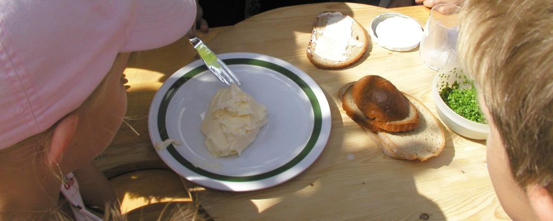 Hier sieht man Kinder bei der Herstellung von Butter.