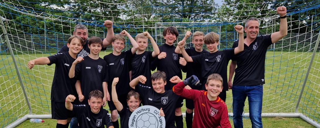 Hier sieht man die Meistermannschaft der JFG Region Harburg D2 mit ihren Trainern Thomas Blaschke und Rainer Baumann.