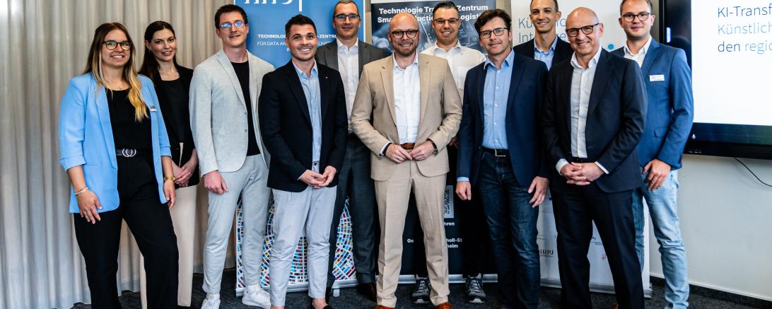 Staatsminister Mehring (Mitte) im neu eröffneten KI-Regionalzentrum Leipheim in Nördlingen mit den neu ins Förderprogramm KI-Transfer-Plus aufgenommen Unternehmern um Jörg Schwarzer vom gleichnamigen Reiseunternehmen (rechts hinter Mehring). 