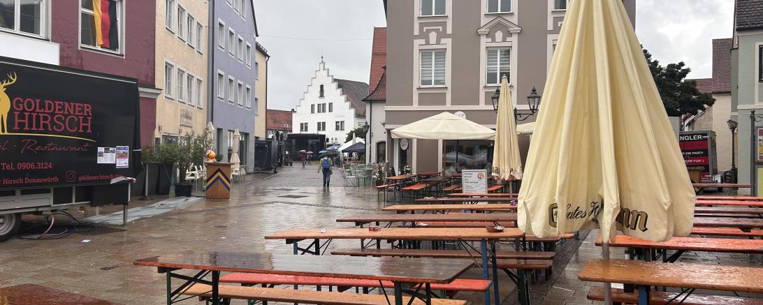 Das Bild zeigt leere Bierbänke im Regen auf dem Inselfest. 