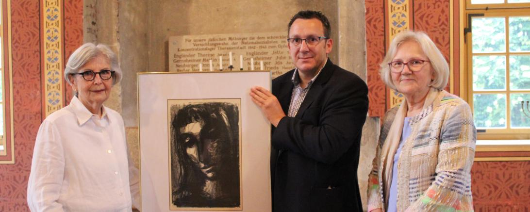 Branko Schäpers und Doris Ritter (beide Caritas) übergeben das Gemälde an Sigi Atzmon vom Freundeskreis der Synagoge Hainsfarth. 