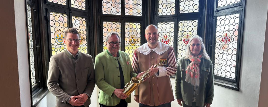 Dr. Joachim Herzog (zweiter v. links) übergibt gemeinsam mit seiner Ehefrau Anne Herzog Stadtkapellmeister Oliver Körner (zweiter v. rechts) und Oberbürgermeister David Wittner (erster von links) ein nahezu neuwertiges Altsaxophon aus seinem Privatbesitz für die Knabenkapelle Nördlingen.