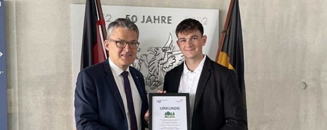 Hier sieht man Herr Roderich Kiesewetter (links) und Daniel Ziegelbauer (rechts) bei der Übergabe der Baumurkunde als Dankeschön.