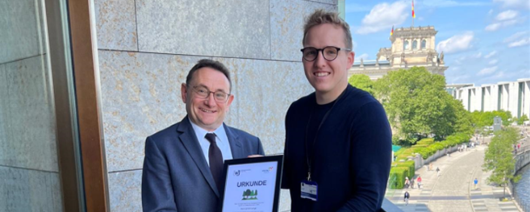Hier sieht man Herr Ulrich Lange (links) und Johannes Steinmeyer (rechts) bei der Übergabe der Baumurkunde als Dankeschön.