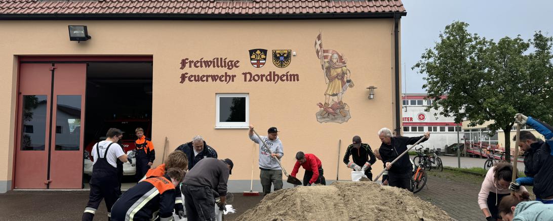 Freiwillige Helfer füllen in Nordheim Sandsäcke.