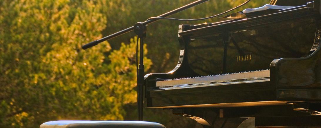 Hier sieht man ein Piano bei einem open-Air-Konzert.