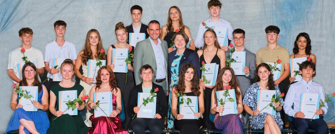 Die stellvertretende Landrätin Claudia Marb und Schulleiter Christian Sattich gratulieren 19 Absolventinnen und Absolventen der Realschule Rain zum Realschulabschluss mit der Note 1 vor dem Komma, ganz besonders der Schulbesten Yvonne Meyr zum Traumschnitt von 1,1 