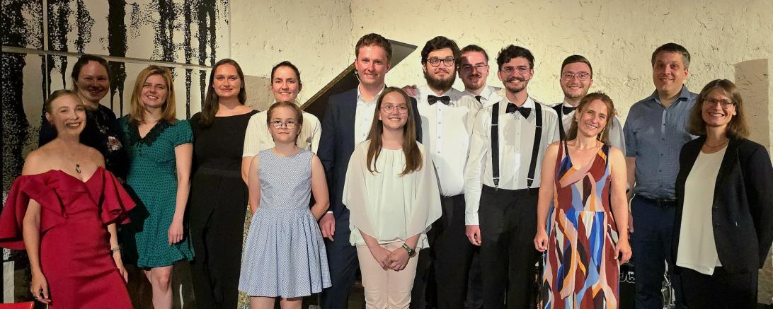 Auf dem Bild zu sehen: (von links. 1. Reihe): Maresa Matzek, Sophia Graf, Marlene Karl, Anita Bast und Silke Kessler. (von links zweite Reihe): Sabine Madden, Anna Unflath, Katharina Kuberstejn, Dr. Franziska Graf, Philipp Schmid, „The Swinging Jangos“ (mit den Bandmitgliedern Ludwig Müller/ Daniel Oswald/ Alexander Dollmann/ Lukas Rikanovic) und Christoph Kessler.