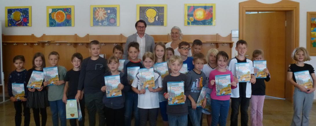 Die Kinder der dritten Klasse der Johann-Wilhelm-Klein Grundschule in Alerheim hatten großen Spaß an den Büchern „Häuser, Straßen, Tunnel bauen – wie geht das?“, die ihnen von Obermeister Wolfram Uhl von der Bauinnung Nordschwaben überreicht wurden.