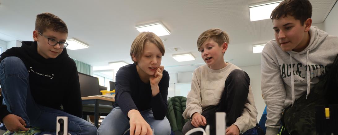 Felix Büringer, Emil Hildebrand, Sebastian Schmid und Artem Geier (v.l.n.r) programmieren in der Robotik-AG des THG Nördlingen schon die fortgeschrittenen Roboter und testen, ob ihre Roboter die entsprechenden Wege auf der Spielfeldmatte zurücklegen.