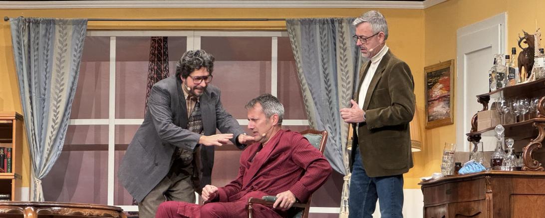 Während Pierre Brochant (gespielt von Steffen Höhn, Bildmitte) durch seinen Hexenschuss an den Sessel gefesselt ist, versuchen ihm Francois Pignon (Gerhard Munk, links im Bild) und Juste Leblanc (Marcus Prügel, rechts im Bild) dabei zu helfen, seine Ehe zu retten.