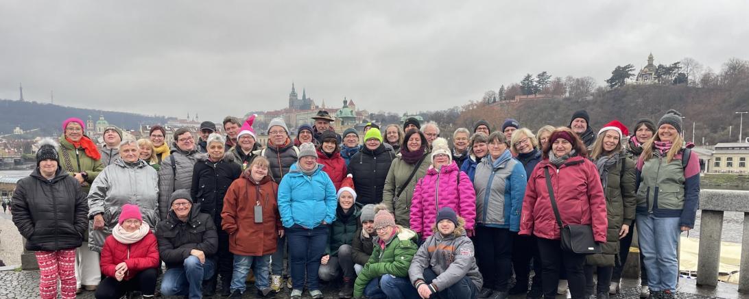 Das Foto zeigt die bunte Reisegruppe vor der Kulisse der Prager Burg.