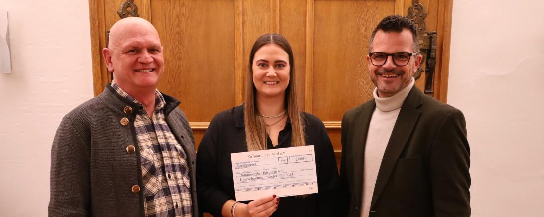 Andreas Gansmeier, der Vorsitzende des Vereins Kulinarium, und Vereinsmitglied Katharina Link übergeben einen Spendenscheck in Höhe von 2.000 Euro an Jürgen Sorré, den Vorsitzenden der Stiftung „Donauwörther Bürger in Not“.