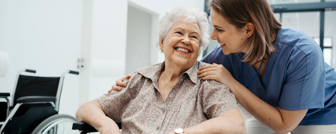 Das Bild zeigt eine Pflegekraft mit einer Seniorin. 