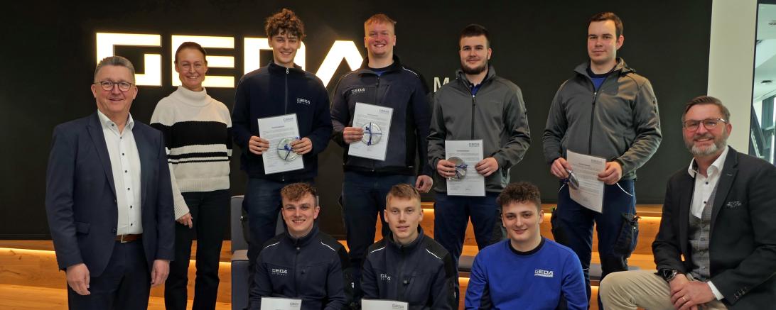 Stolz präsentieren die acht Azubis ihre Abschlussurkunden.