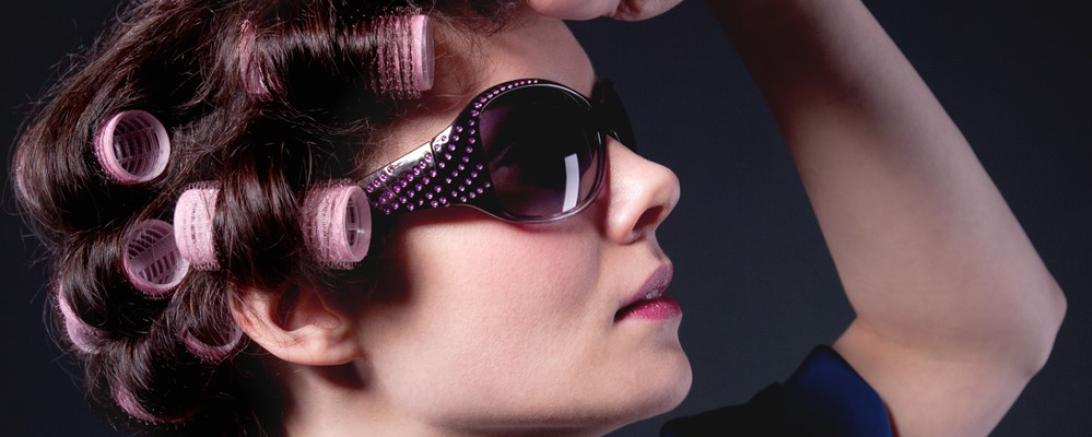 Frau mit Lockenwicklern und Sonnenbrille und Satin Morgenmantel