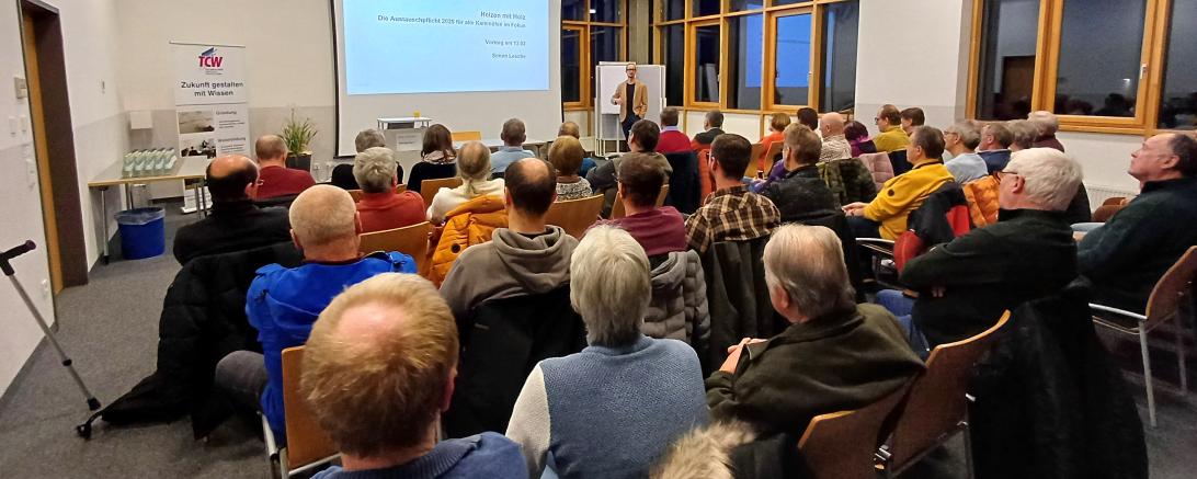 Referent Simon Lesche (TFZ – Technologie- und Förderzentrum im Kompetenzzentrum für Nachwachsende Rohstoffe) informiert im Rahmen eines Fachvortrags vor zahlreichem Publikum die Austauschpflicht für Holzöfen 