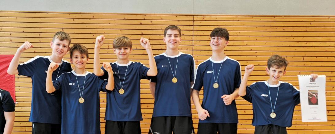 Jungs auf einem Podest mit Medaillen, die jubeln