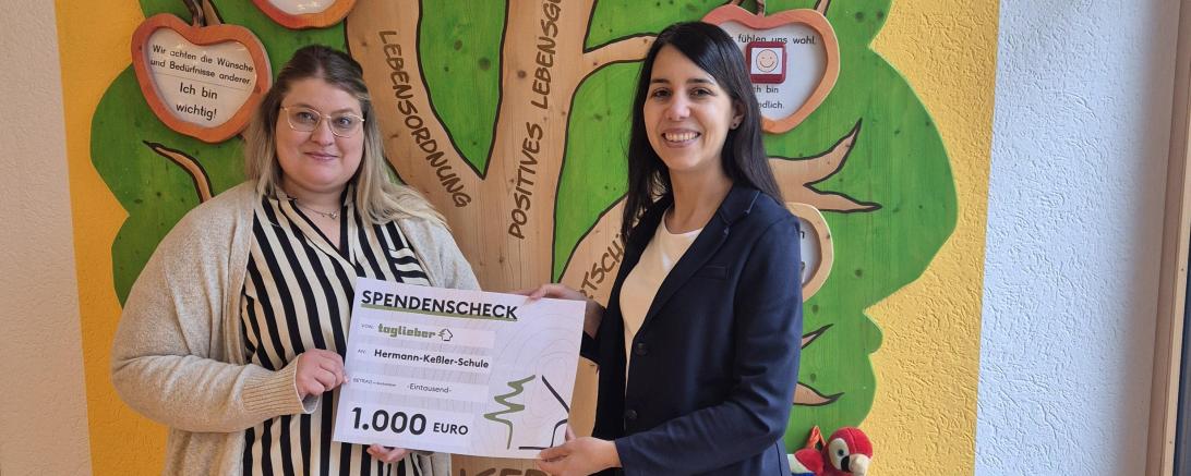 zwei Frauen die einen Geldscheck in der Hand halten