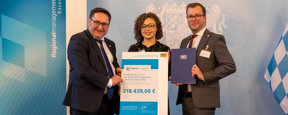 Staatssekretär Tobias Gotthardt, Regionalmanagerin Laura Brummer und Stabstellenleiter Klemens Heininger bei der feierlichen Übergabe des Förderbescheids.