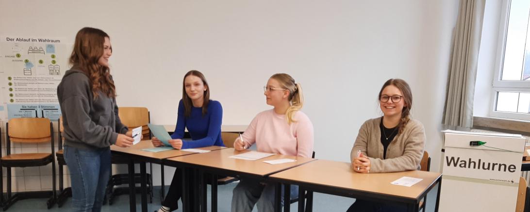 4 Schülerinnen an einer Wahlurne